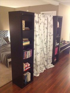 a room with a book case and some books on the shelves next to a bed