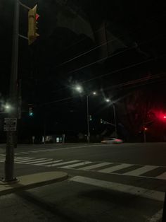 an empty street at night with traffic lights