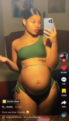 a pregnant woman taking a selfie with her cell phone