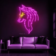 a neon pink wolf head on a black wall next to a white couch in a dark room