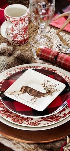 the table is set with red and white plates, silverware, and napkins