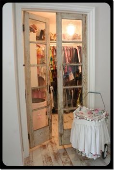 an open door leading to a closet with clothes on hangers