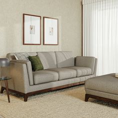 a living room scene with focus on the couch and chair, coffee table and ottoman