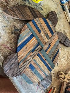 a wooden turtle sitting on top of a table next to other woodworking tools and supplies