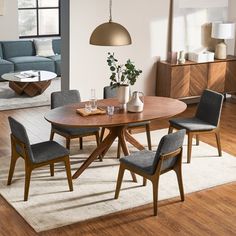 a dining room table with chairs and a rug on the floor