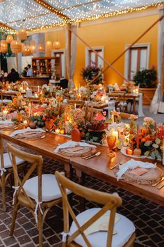 a long table is set up with candles and place settings for an outdoor dinner party