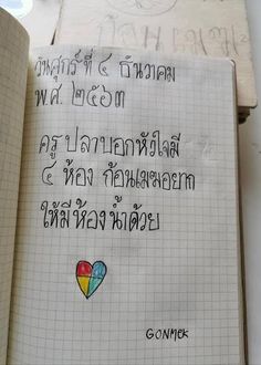 an open book with writing on it and a rainbow heart in the middle, surrounded by handwritten words