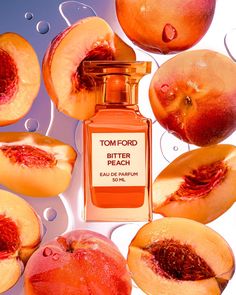 a bottle of tom ford bitter peach perfume surrounded by sliced peaches and pieces of fruit