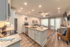 a kitchen with an island, sink and stove top oven next to a dining room table