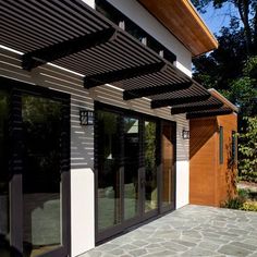 the outside of a house with an awning and stone walkway leading up to it