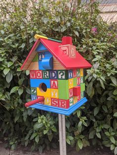 a colorful birdhouse with letters and numbers painted on it