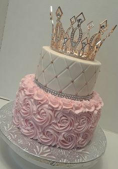 a three tiered cake decorated with pink roses and a tiara on the top