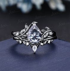 a white diamond ring on top of a blue cloth with flowers and leaves around it