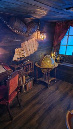 a room with wooden floors and lots of books on the shelves, including a globe