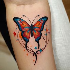 a colorful butterfly tattoo on the arm