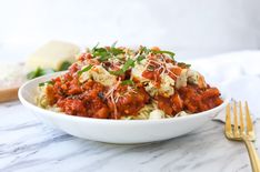 a white bowl filled with pasta covered in sauce