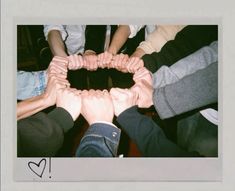 a group of people holding hands in the shape of a heart with one person's hand