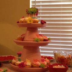 three tiered cupcake display with fruit and flowers