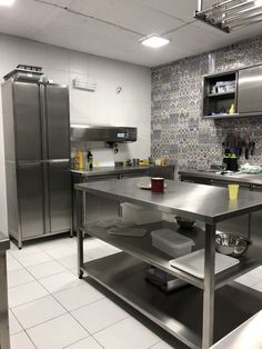 an industrial kitchen with stainless steel appliances and tile flooring is pictured in this image