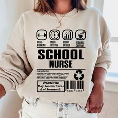 a woman wearing a sweatshirt with the words school nurse printed on it in black and white