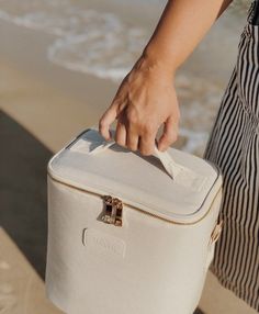 a person holding a white bag on the beach