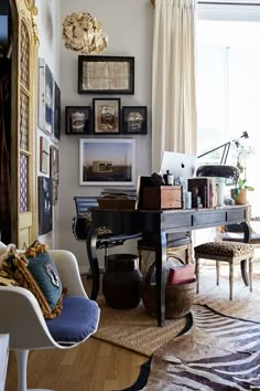 a living room filled with lots of furniture and pictures on the wall above it's piano