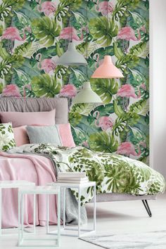 a bedroom with pink flamingos and green leaves on the wall behind it is a bed