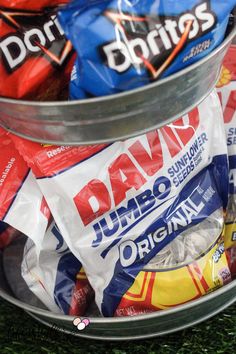 two buckets filled with different types of candy on top of green carpeted floor