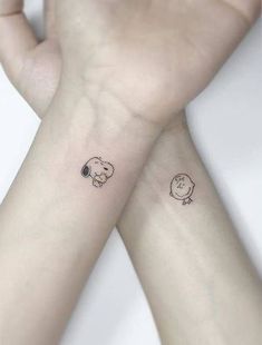 two small tattoos on the wrist of someone's left and right arm, one with a dog