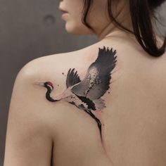 a woman with a bird tattoo on her back