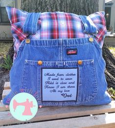 a blue jean purse sitting on top of a wooden bench next to a tree and sign