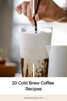 a person holding a spoon over a cup filled with coffee