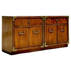 a wooden cabinet with two drawers and brass handles