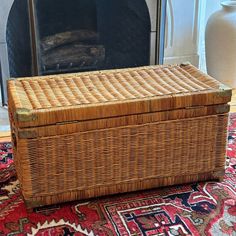 a wicker basket sitting on top of a rug next to a fire place