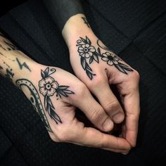 two hands with tattoos on them are holding each other's fingers and touching their palms