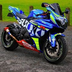 a blue motorcycle parked on top of a gravel road