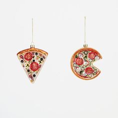 two pieces of pizza hanging from hooks on a white wall with the letter g in it