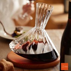 a wine decanter sitting on top of a wooden table