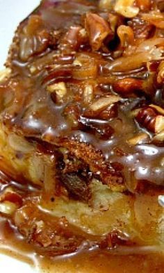 some food is sitting on a white plate with chocolate sauce and pecans in the middle