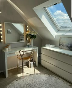 an attic bedroom with a desk, chair and vanity in the corner under a slanted skylight