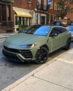 a green lamb suv parked on the side of the road