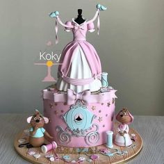 there is a cake that looks like a princess dress on top of the cake, with other decorations around it