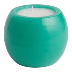 a teal colored candle sits in front of a white background