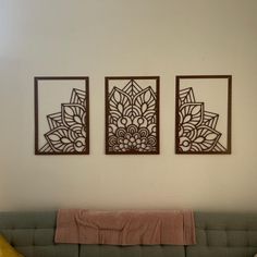 three pieces of art hanging on the wall above a couch