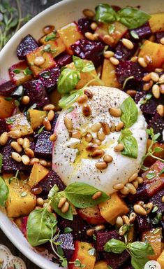 a white bowl filled with beets, spinach and poached egg on top