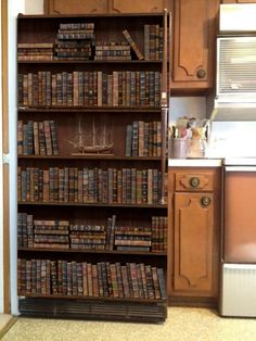 a book shelf filled with lots of books in a kitchen