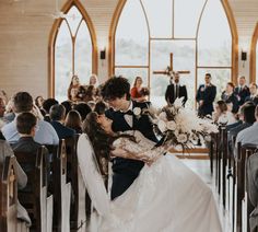 a bride and groom kissing in front of an audience