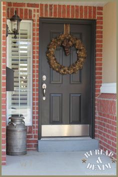 a black front door with a wreath on it