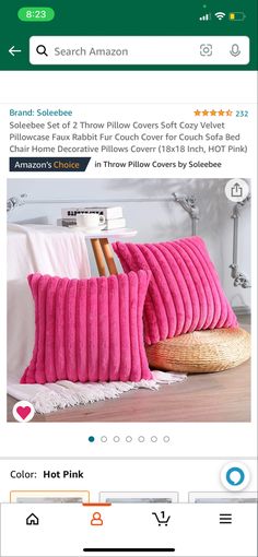 two pink pillows sitting on top of a bed