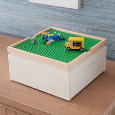 a toy truck is sitting on top of a lego box that's filled with toys